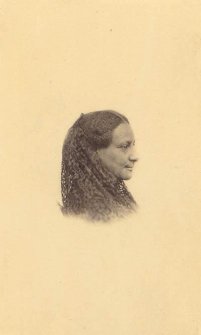 <p>A black and white photograph with a yellow tinge depicting a Black woman's face and shoulders in profile. The woman is smiling and her hair is braided and falling over her shoulders.</p>